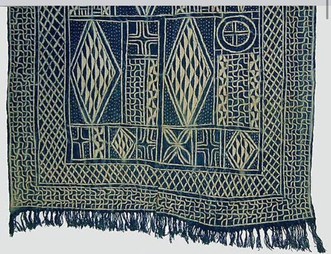 Détail d'un tissu Ndop traditionnel montrant les motifs géométriques complexes en losanges et zigzags